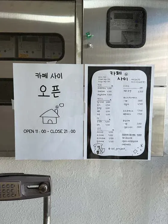 카페 사이 입구에 게시된 영업 안내와 메뉴판